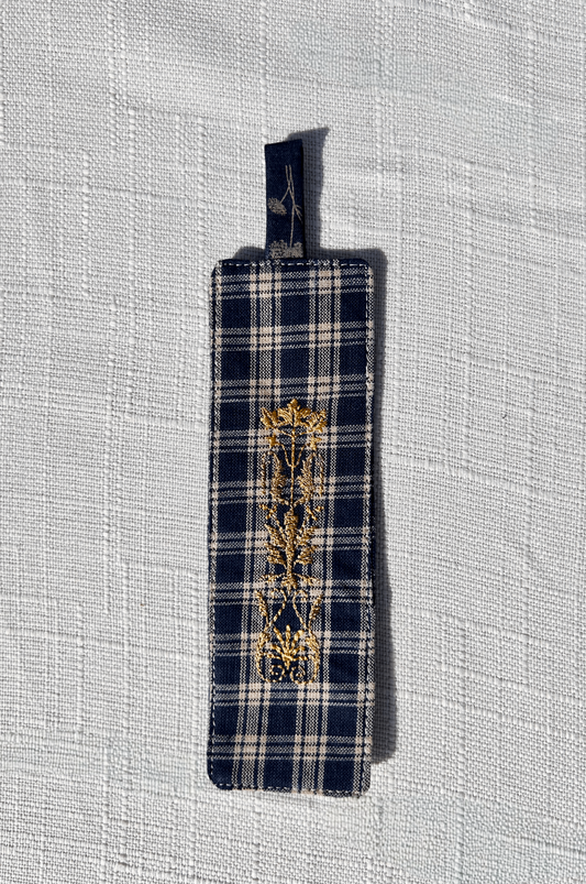 Navy and white plaid standard size fabric bookmark with tab with golden crest embroidery on the front and back . a part of a matching set with a glasses case