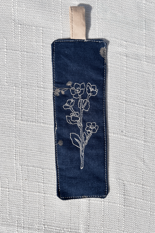 Navy blue  floral cotton handmade bookmark with floral  line art embroidered on the  front and back and an extended tab in tan 